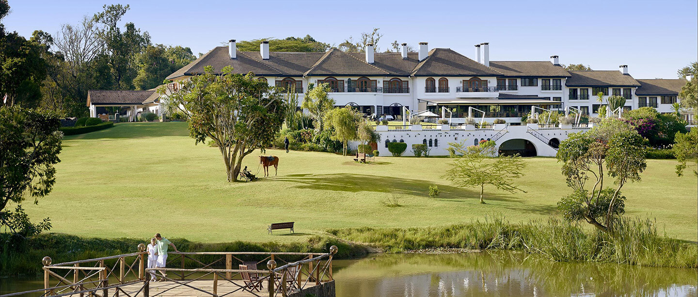 Fairmont Mount Kenya Safari Club main clubhouse at golden hour with the snow-capped summit of Mount Kenya behind, Nanyuki Kenya